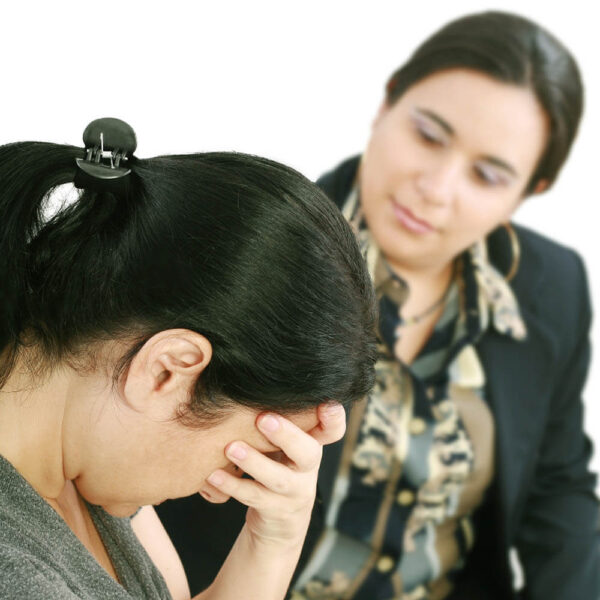 A visibly upset woman talking with a counselor