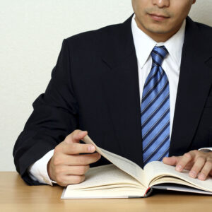 A man in a suit and tie reading a book