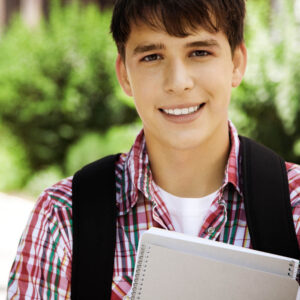 A male student holding notebooks