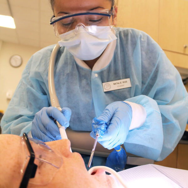 A female dental assistent cleaning teeth