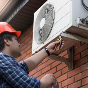 A man connecting an outdoor air conditioning unit
