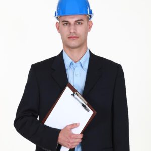 A man wearing a hard hat and holding a clipboard